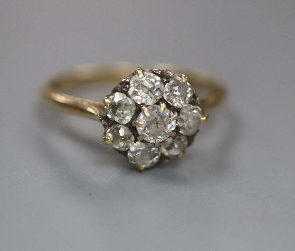 An early 20th century 18ct and old round cut diamond set cluster ring, size P, gross 2.2 grams.